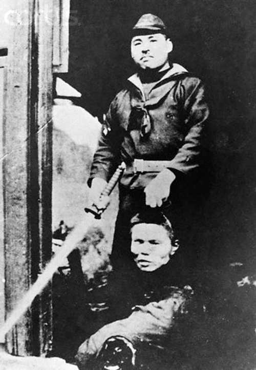 Smiling Japanese Soldier Displays Severed Head