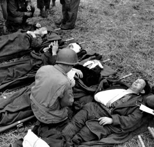 Army medic checks wounded civilians