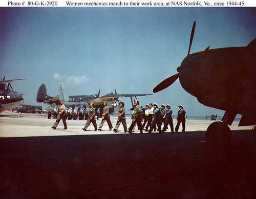 Women mechianc march to their work area, at NAS Norfolk, Va