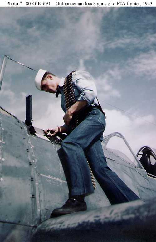 Ordnance man loads guns of a F2A fighter