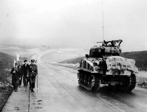 Tank passing surrendering soldiers