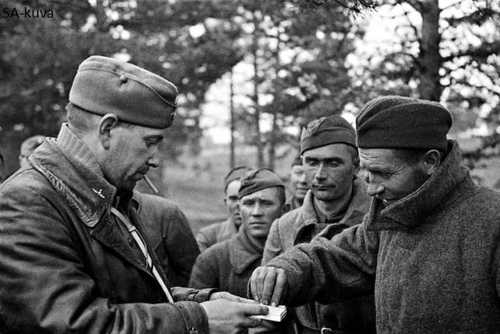 Finnish officer with Soviet prisoners in Aunus