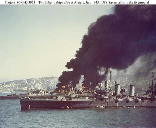 Two Liberty ships afire at Algiers, July 1943, USS Savannah is in the foreground