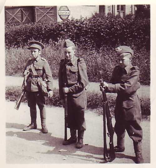 3 childrens with captured uniforms and weapons.